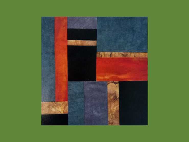 A green background with a quilt block on top. The quilt block is abstract and made of rectgangles of various sizes with black, tan, blue, and red textured fabrics.