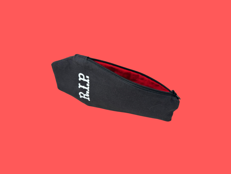 A red background with a black pouch, in the shape of a coffin, slightly unzipper revealing a red interior. On the outside of the pouch is "R.I.P." in white letters